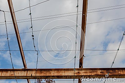 Gridwork of overhead beams, painted and rusted, against a blue sky Stock Photo