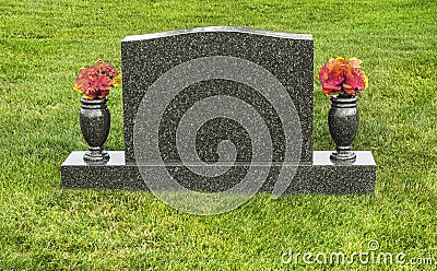 Single blank tombstone in cemetery with flowers Stock Photo