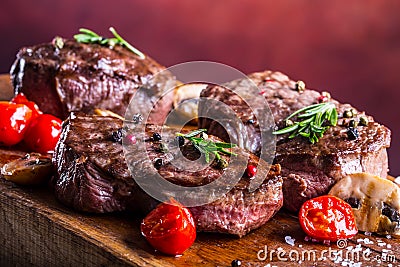 Grill beef steak. Portions thick beef juicy sirloin steaks on grill teflon pan or old wooden board Stock Photo