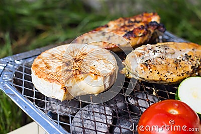 Grill with vegetables. Tomatoes, zucchini, chicken and cucumber. On the grid grill are fried vegetables. Stock Photo