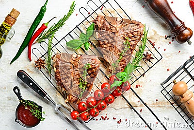 Grilled aged T-bone steak with rosemary on a white wooden background. Top view. Rustic style Stock Photo