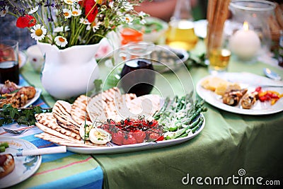 Grilled asparagus and tomatoes with pita bread on picnic table Stock Photo