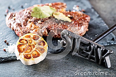 Grilled beef steak fillet with ingredients like sea salt, pepper, onion and metal letters on black board, food background for rest Stock Photo