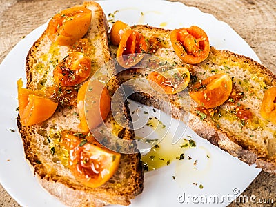 Grilled bread bruschetta with Italian tomatoes, orange color, very good and lasting, seasoned with olive oil and oregano Stock Photo