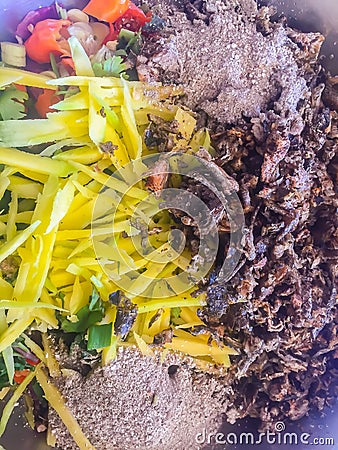 Grilled Chameleon meat sliced or minced and cook with sliced mango, chilli and herb. Native Thai and Laos food, Koy Kapom Stock Photo