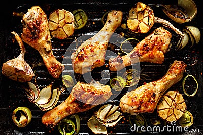 Grilled chicken legs with aromatic herbs and vegetables on a barbecue plate Stock Photo