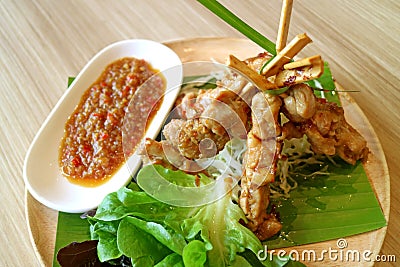 Grilled Chicken with Spicy Sauce and Green Salad Served on Wooden Plate Stock Photo