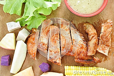 Grilled chicken steak with slice variety fresh fruit arranging on chopping block Stock Photo