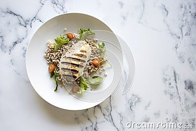 Grilled Chicken and Wholegrain Salad on a Marble Background Stock Photo