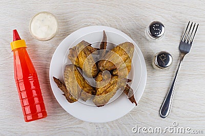 Grilled chicken wings in plate, ketchup, mayonnaise, salt, pepper Stock Photo