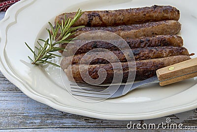 Grilled chipolata sausages on a plate Stock Photo