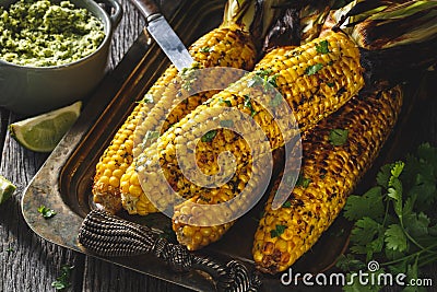 Grilled Corn On Cob On Barbecue with herbs Butter Stock Photo