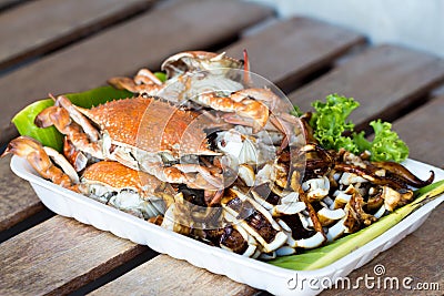 Grilled crabs and squid in foam tray Stock Photo