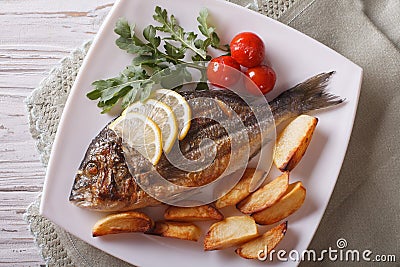 Grilled dorado fish with fried potatoes closeup. horizontal top Stock Photo