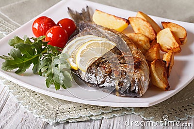 Grilled dorado fish with potatoes closeup. horizontal Stock Photo