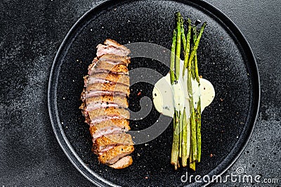 Grilled duck breast steak with baked asparagus. Black background. Top view Stock Photo