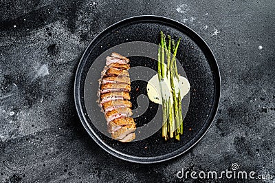 Grilled Duck fillet steaks with asparagus. Black background. Top view Stock Photo