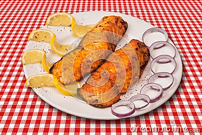 Grilled fish fillet decorated with slised lemon and onion Stock Photo