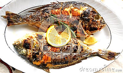 Grilled fish, sea bream, dorada on the plate Stock Photo