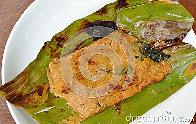 Grilled flower crab with curry paste in banana leaf on plate Stock Photo