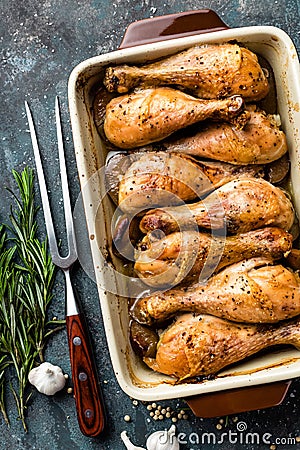 Grilled fried roast chicken legs, drumsticks on dark background, meat with ingredients for cooking Stock Photo