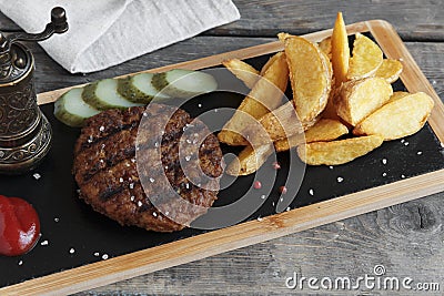 Grilled hamburger with potatoes and pickled cucumber sauce Stock Photo