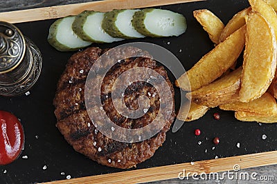 Grilled hamburger with potatoes and pickled cucumber sauce Stock Photo