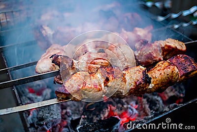 Grilled kebab cooking on metal skewers grill. Stock Photo