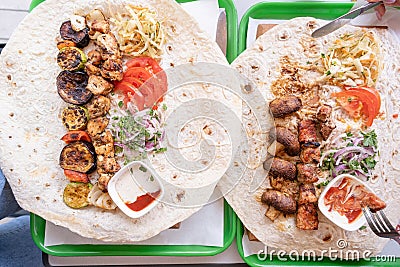 Grilled kebab with pita bread and vegetables on tray in summer fast food street cafe, top view Stock Photo