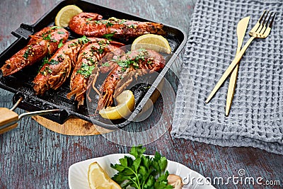 Grilled large queen shrimps with lemon and spices on the grill pan Stock Photo