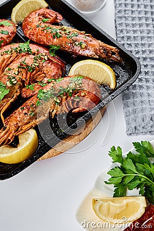 Grilled large queen shrimps with lemon and spices on the grill pan Stock Photo