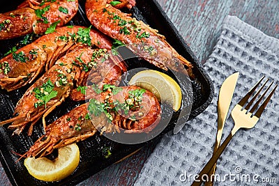 Grilled large queen shrimps with lemon and spices on the grill pan Stock Photo