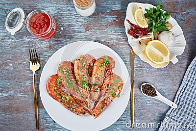 Grilled large queen shrimps with lemon and spices on the plate Stock Photo