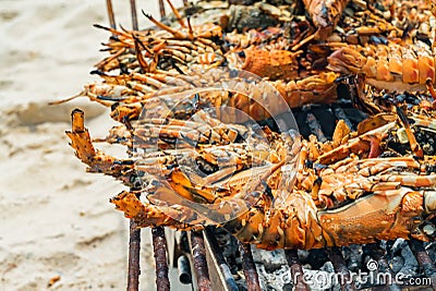 Grilled Lobster Cook on Charcoal Stove on sand beach, Zanzibar, Tanzania Stock Photo