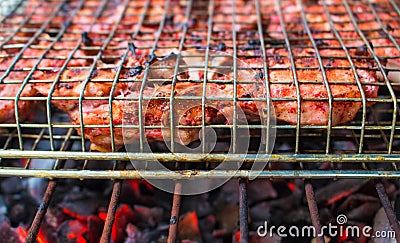 Grilled meat on fire closeup photo. Red meat barbecue cooking. Stock Photo