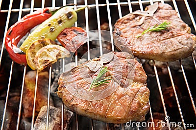 Grilled pork chop and vegetables on the flaming grill Stock Photo