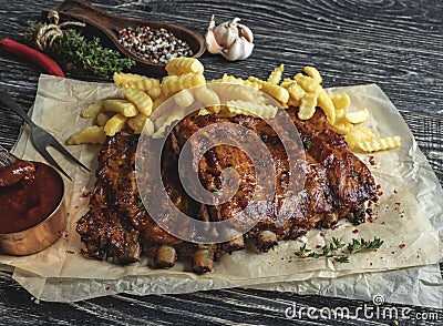 Grilled pork ribs with sauce on a cutting board, french fries Stock Photo