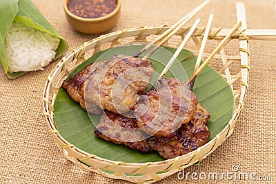 Grilled pork skewers or moo ping in Thai served on bamboo basket Stock Photo