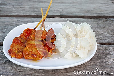 Grilled pork with sticky rice in white plate is a food that Thai people prefer to eat. Stock Photo