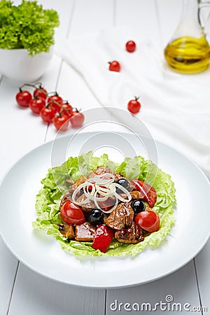Grilled pork warm salad with sauce, tomatoes, champignon mushrooms, pepper Stock Photo