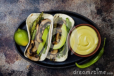 Grilled portobello, asparagus, bell peppers, green beans fajitas. Poblano mushroom tacos with jalapeno, cilantro, avocado crema Stock Photo