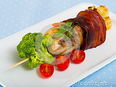 Grilled quail with Iberian ham fried, served on skewers with vegetables Stock Photo