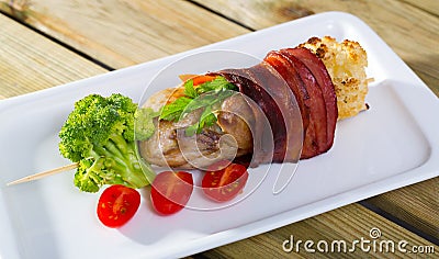 Grilled quail with Iberian ham fried on skewers with vegetables Stock Photo