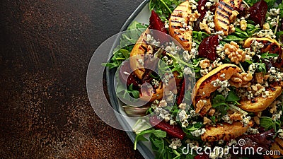 Grilled quince salad with baked and fresh grated beetroot, blue cheese, walnuts on rustic table Stock Photo