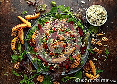 Grilled quince salad with baked and fresh grated beetroot, blue cheese, walnuts on rustic table Stock Photo