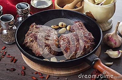 Grilled rib eye steak composition on grill iron pan on wooden background Stock Photo