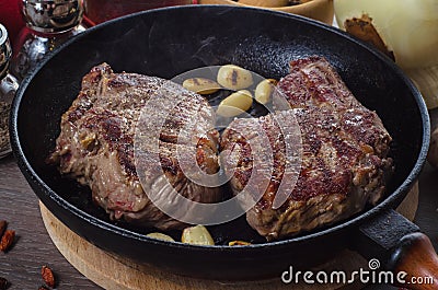 Grilled rib eye steak composition on grill iron pan on wooden background Stock Photo