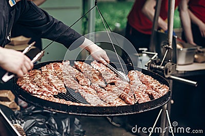 grilled ribs meat. man holding steel tongues and roasting beef p Stock Photo