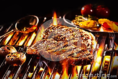 Grilled rump steak with mushrooms over flames Stock Photo