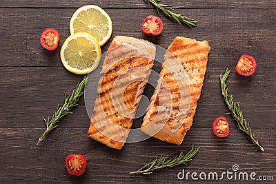 Grilled salmon and tomato, lemon, rosemary on the wooden backgro Stock Photo